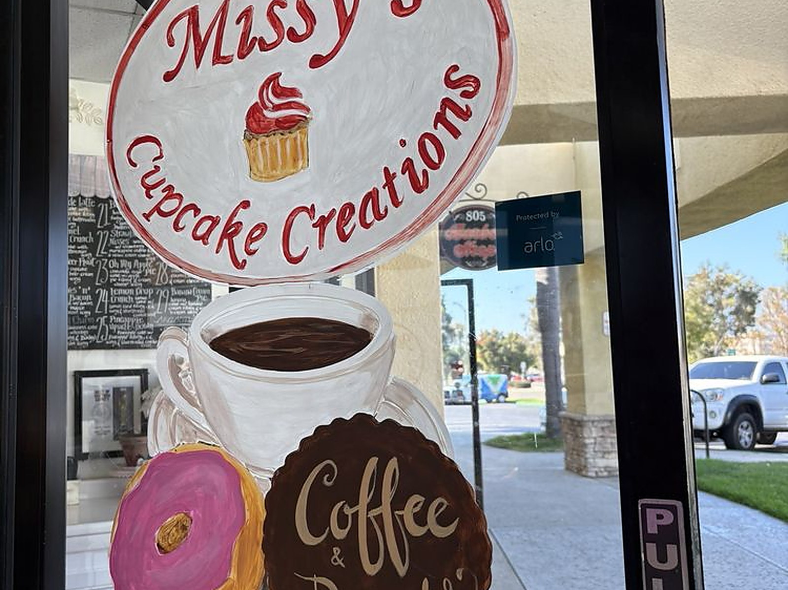 Coffee and donuts, painted on the door — the hand-painted sign at Suite 119